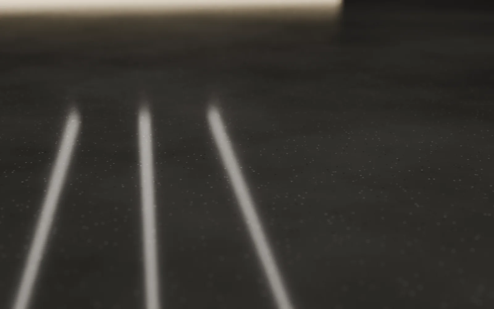 Parlatılmış beton zeminde agrega dokusu ve tavan ışıklarının yansıması, yakın plan